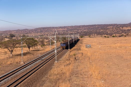 Railway train tracks line travel through dry season rural landscape