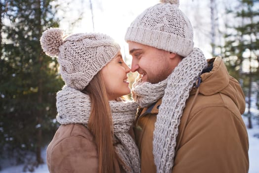 Happy young man and woman in winterwear flirting outside