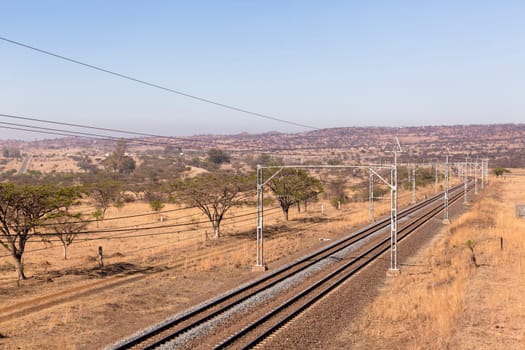 Railway train tracks line travel through dry season rural landscape