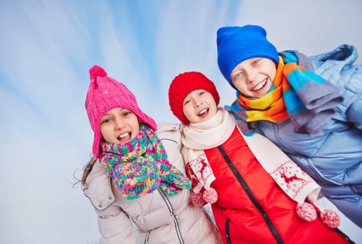 Happy children in winterwear looking at camera with smiles