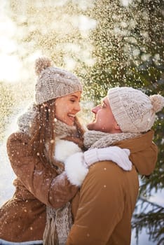 Amorous man and woman enjoying snowfall