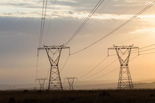 Powerlines electrical cables tower structures stretch over rural countryside