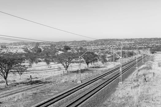 Railway train tracks line travel through dry season rural landscape