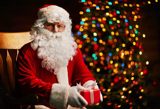 Santa Claus with small giftbox looking at camera