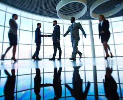 Modern business people against window in office building