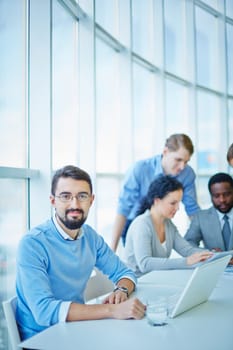 Successful businessman looking at camera in working environment