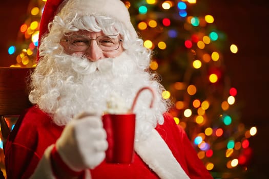 Santa Claus with red cup looking at camera