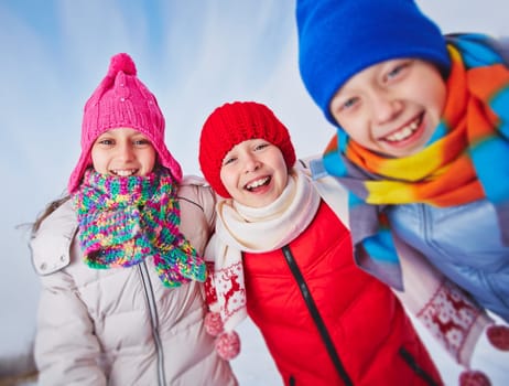Laughing kids in winterwear looking at camera