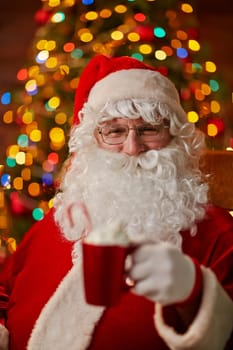 Santa Claus with cup of latte looking at camera