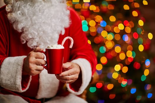 Tasty latte with whipped cream held by Santa