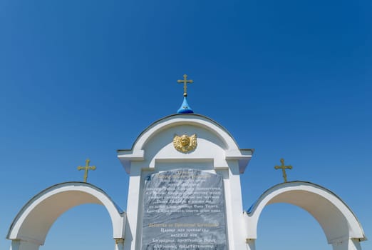Fragment of a prayer to the Holy Mother of God, engraved on the white tricuspid arch with Orthodox crosses over it