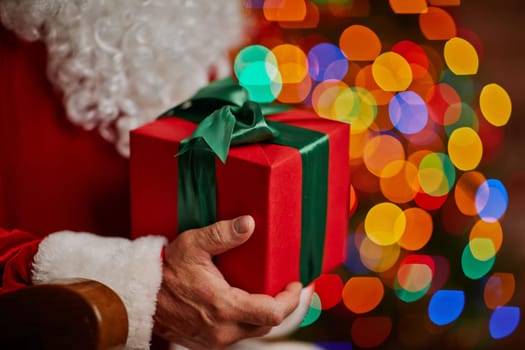 Red box with Christmas gift in Santa hands