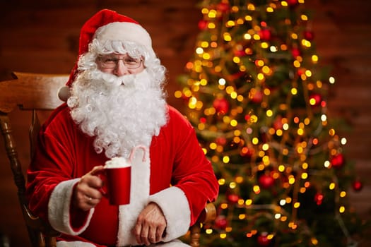 Joyful Santa with cup of latte offering toast for Christmas
