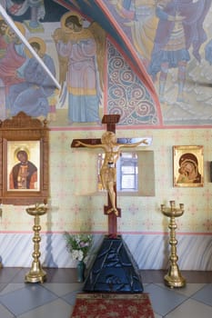Crucifixion of Jesus surrounded by the icons in the church with hand-painted walls and ceilings