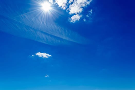 Bright sun shining in the sky with clouds on summer day
