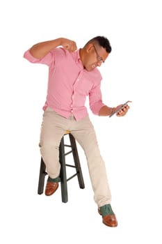 A middle age Hispanic man sitting on a chair and screaming at his tablet.computer, isolated for white background..