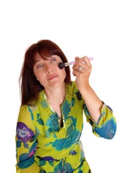 A middle are woman applying makeup with a brush on her face, in closeup, .isolated for white background..