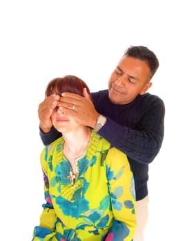 A Hispanic man, standing behind his wife and holding his hands over her.eye's, isolated for white background..