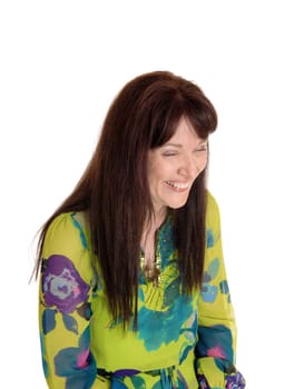 A middle age woman in a nice dress and long brunette hair having fun .and laughing, isolated for white background..