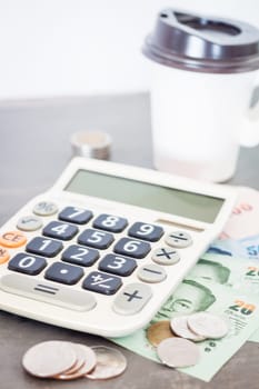 Calculator with money on grey background, stock photo