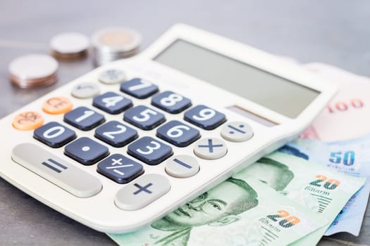 Calculator with money on grey background, stock photo