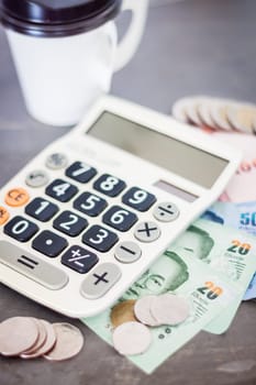 Calculator with money on grey background, stock photo