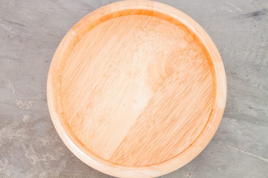 Wooden plate on grey background, stock photo