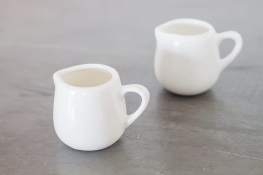 White ceramic pitcher on grey background, stock photo