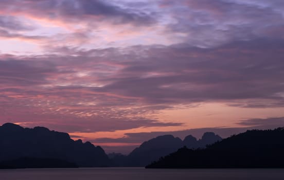 Stunning twilight view of Limestone mountains and lake in Khao Sok National Park, Surat Thani Province, Thailand. Long exposure shot.