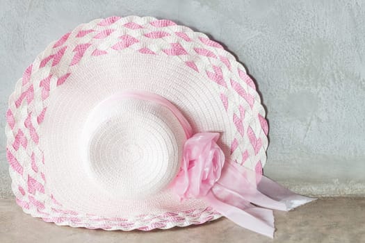 Pink hat with ribbon on grey background, stock photo