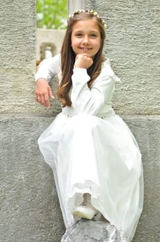 Girl before communion festively dressed in the garden