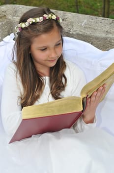 Girl before communion festively dressed in the garden