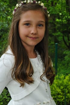 Girl before communion festively dressed in the garden