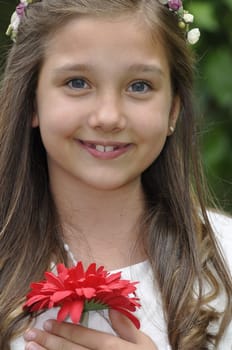 Girl before communion festively dressed in the garden