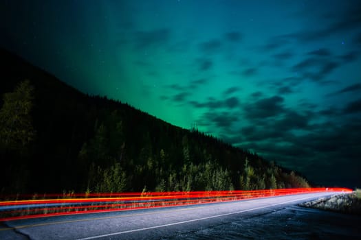 The Northern Lights emerge through the clouds in remote Alaska