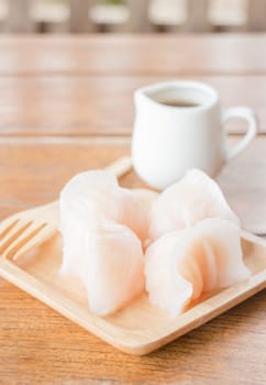 Chinese har gao dim sum dumplings on wooden plate, stock photo