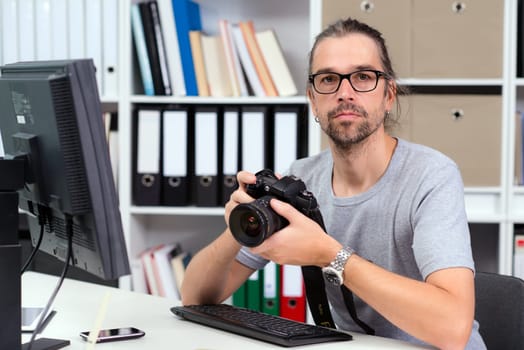 creative man with camera is working in his office