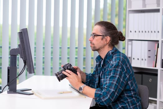 creative man with camera is working in his office