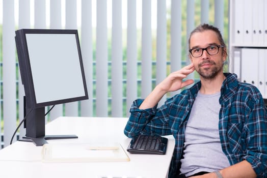 creative man is working in his office and looking in to the camera