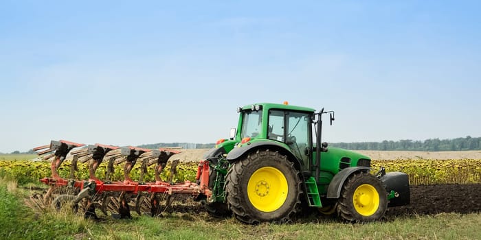 Tractor with plough in the field