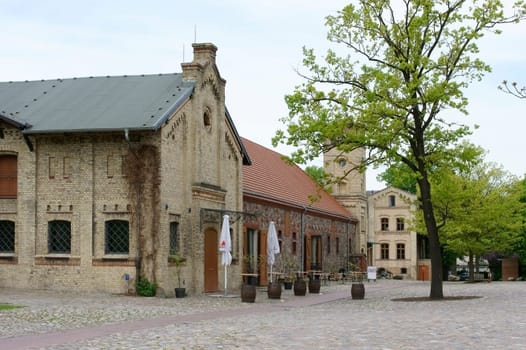 Berlin,Germany – May 05,2015: A brick manor building with a clock tower on the estate park of Britz Castle on May 5,2015 in Germany.