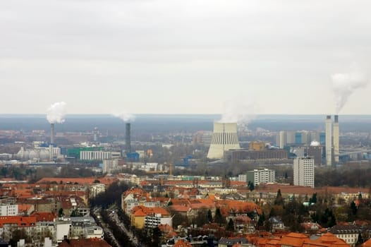 The chimneys of a power plant above the roofs of residential areas in Berlin.