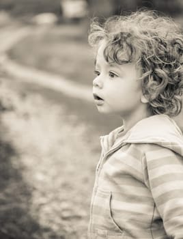 1 year old baby boy walking through the countryside.