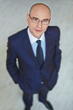 Modern businessman in eyeglasses looking at camera