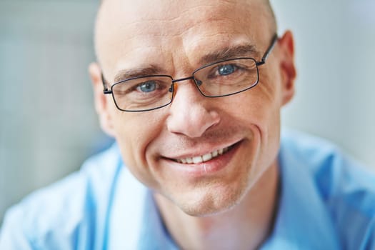 Face of smiling businessman in eyeglasses