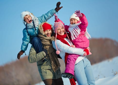 Ecstatic family looking at camera in winter