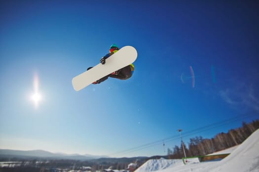 Sportsman on snowboard hanging over snowdrift
