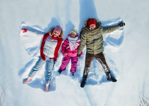 Happy family of three having fun in snowdrift