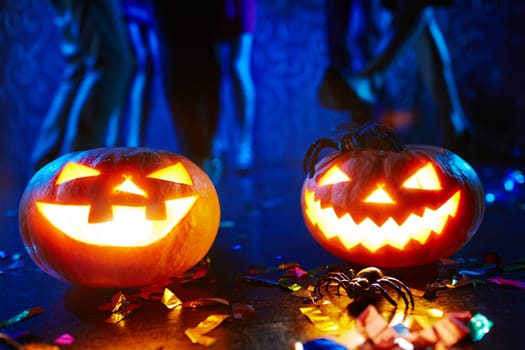 Halloween pumpkins and spiders on background of dancing friends