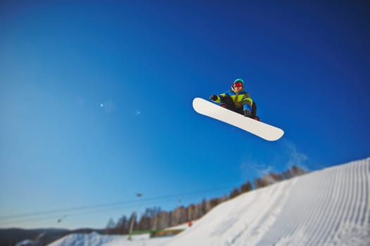 Sportsman on snowboard enjoying vacation on winter resort